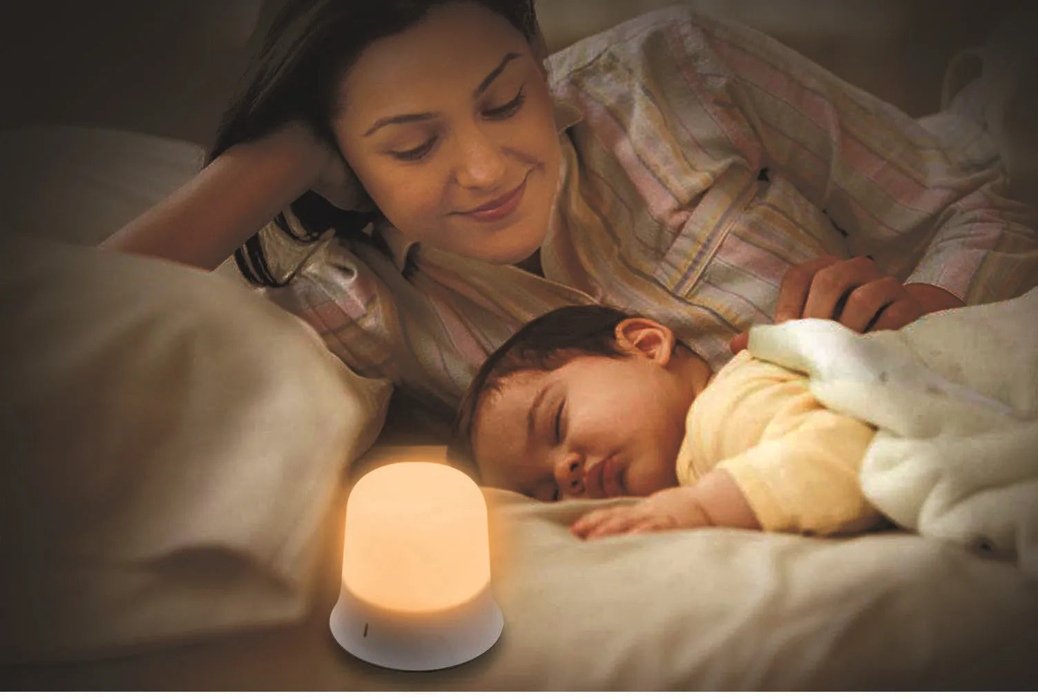 White rechargeable bedside night light with touch controls on a wooden table.