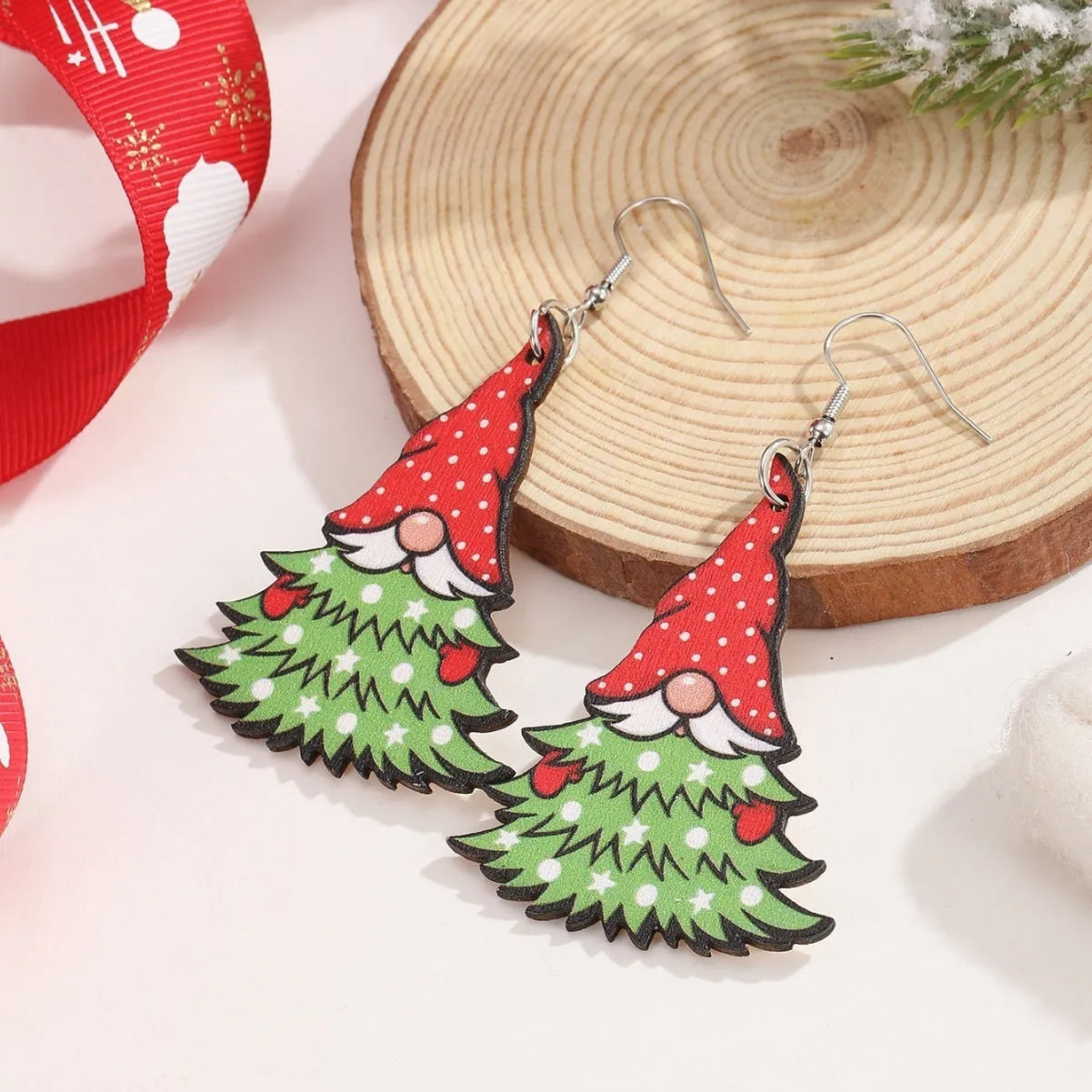 Wooden geometric earrings with printed Christmas tree and snowman Santa Claus designs.