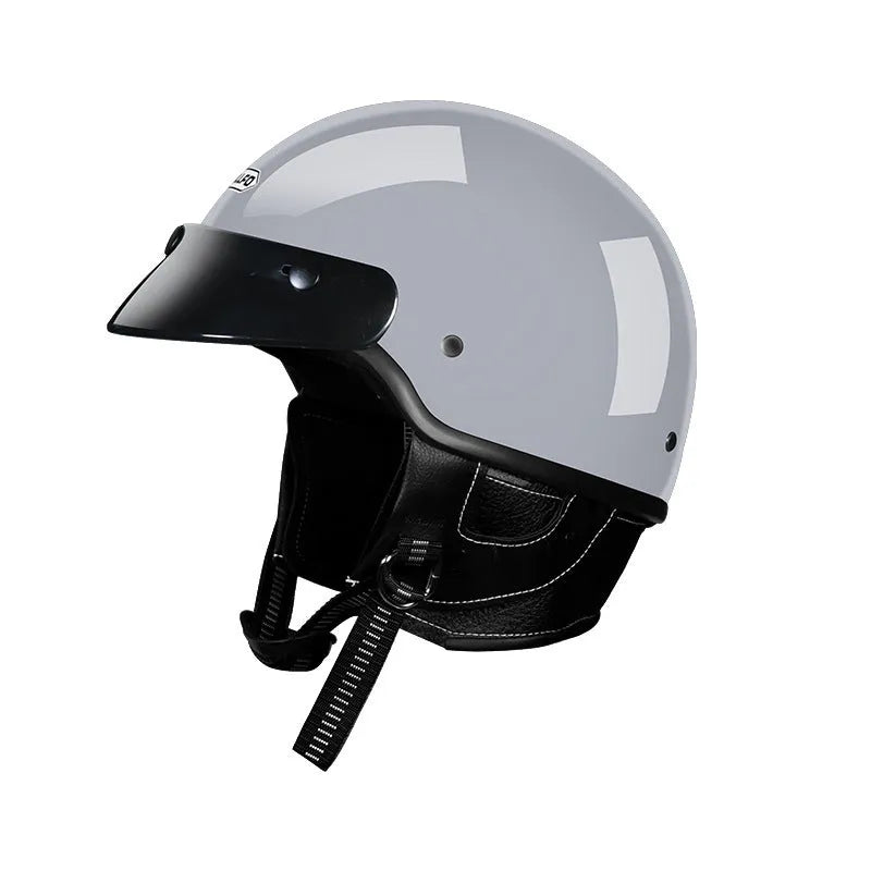 Retro-style motorcycle helmet in cement grey colour on a neutral background.