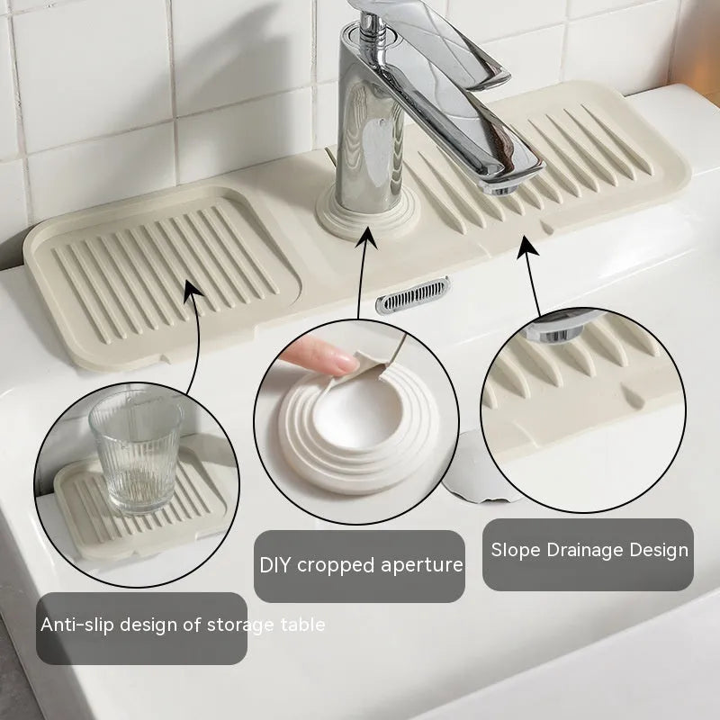 Silicone faucet splash guard pad with sloped design and drain holes on a kitchen sink
