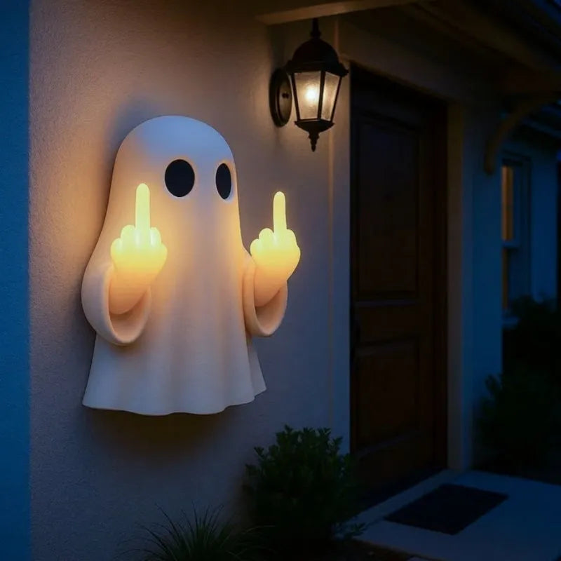 White ghost statue night lamp with LED light on a dark table.
