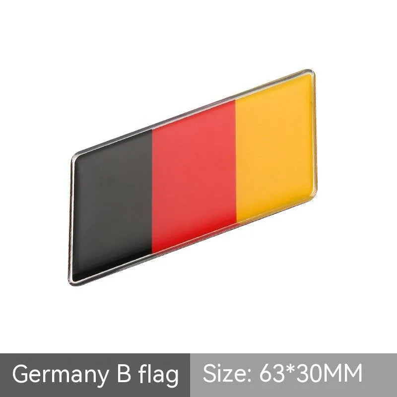 Aluminium national flag car sticker in a parallelogram shape measuring 6.3 by 3 centimetres.