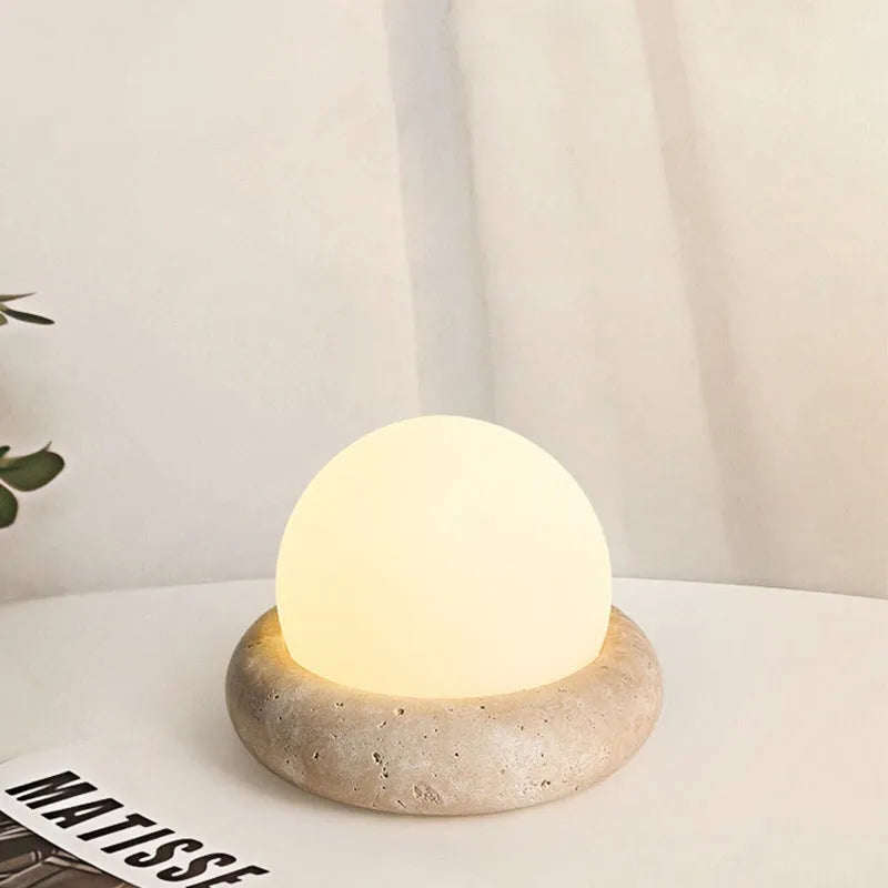 Modern simple bedside night light with remote control on a table.