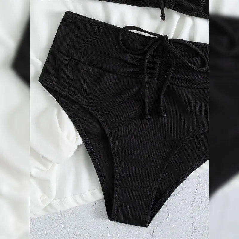 Black women's bikini swimsuit with sling split style and high waist shorts.