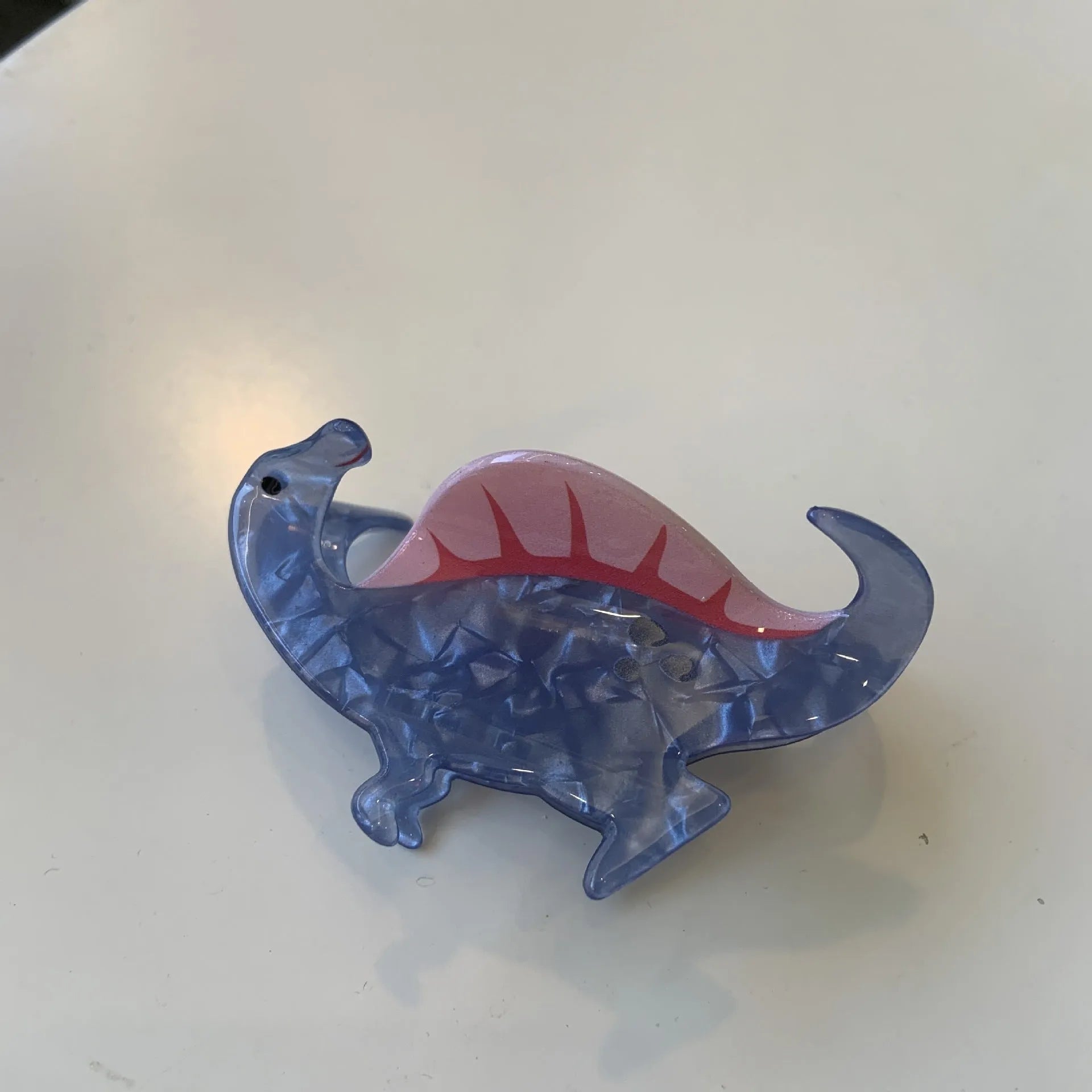 Colourful dinosaur-themed acrylic jaw hair clip showing multiple design options
