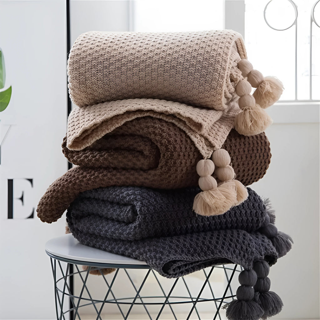 Nordic style fringed knit ball acrylic throw blanket in beige, laid flat showing 130x170cm size.