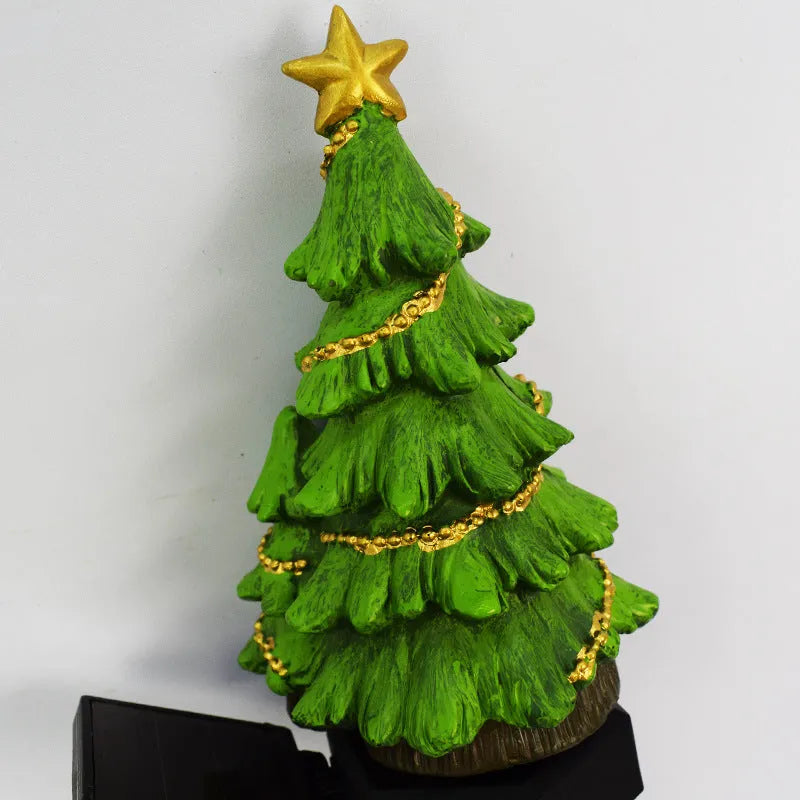 Solar Christmas tree ground plug light with warm white LED, resin body and 40 x 40mm solar panel for outdoor garden use.