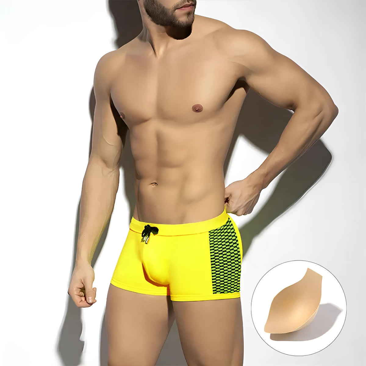 Men's yellow polka dot print swimming boxers with a black ribbon detail on a mannequin.