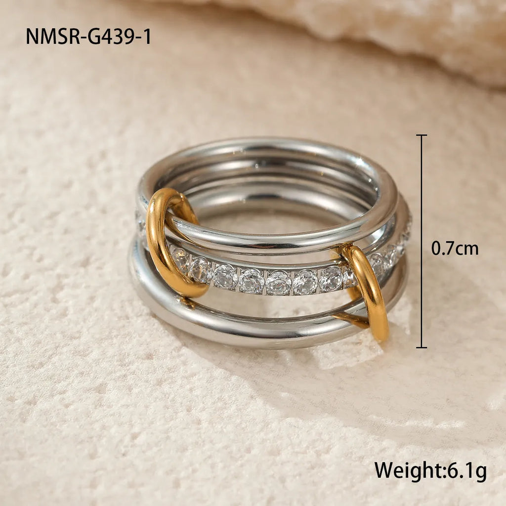 Stacked gold plated stainless steel rings with exaggerated designs on woman's hand