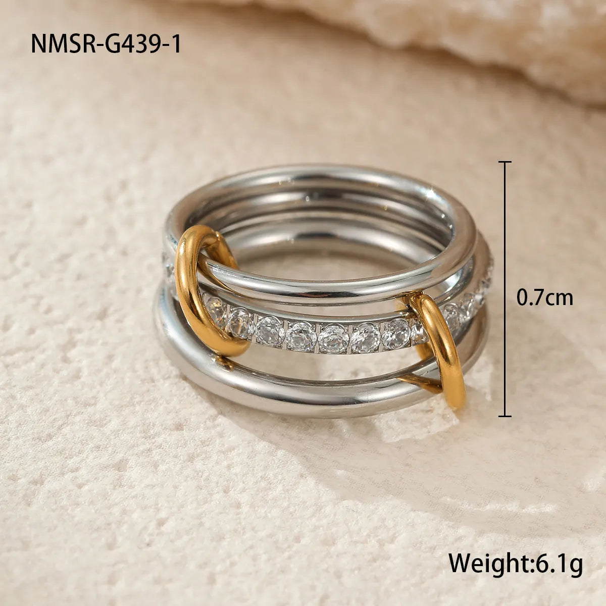 Stacked gold plated stainless steel rings with exaggerated designs on woman's hand