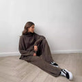 Women's acrylic knit sweater suit with side-slit top and matching trousers in dark grey