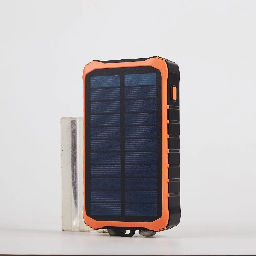 Orange and green hand solar power bank with solar panel, hand crank, dual USB ports, and LED light.