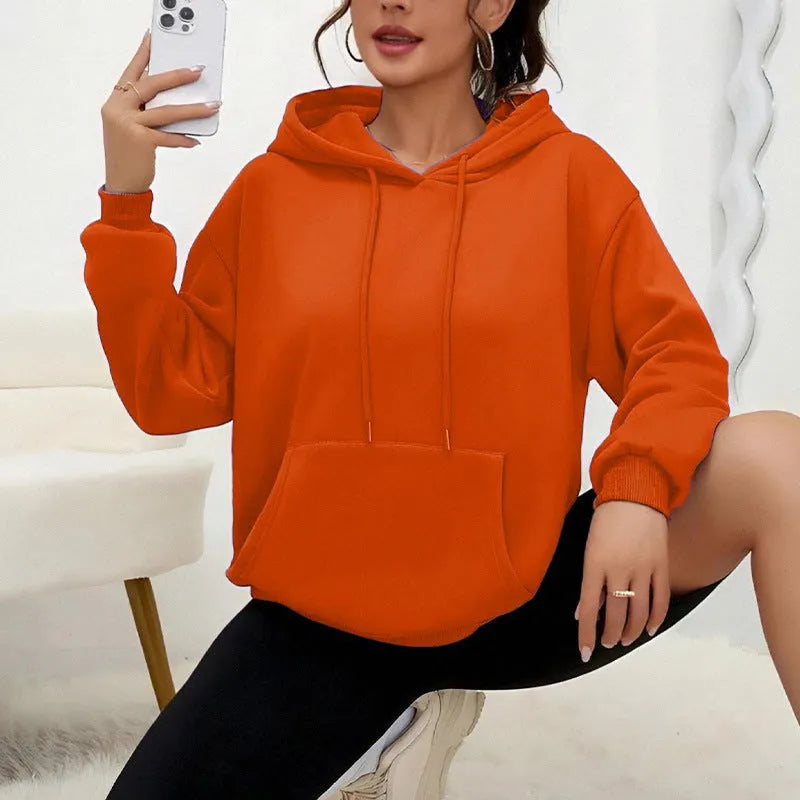Women's loose grey drawstring hoodie with front pockets on a hanger.