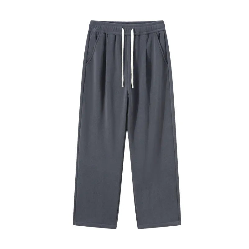 Men's loose fit apricot coloured fleece-lined sports pants with a drawstring waist on a hanger