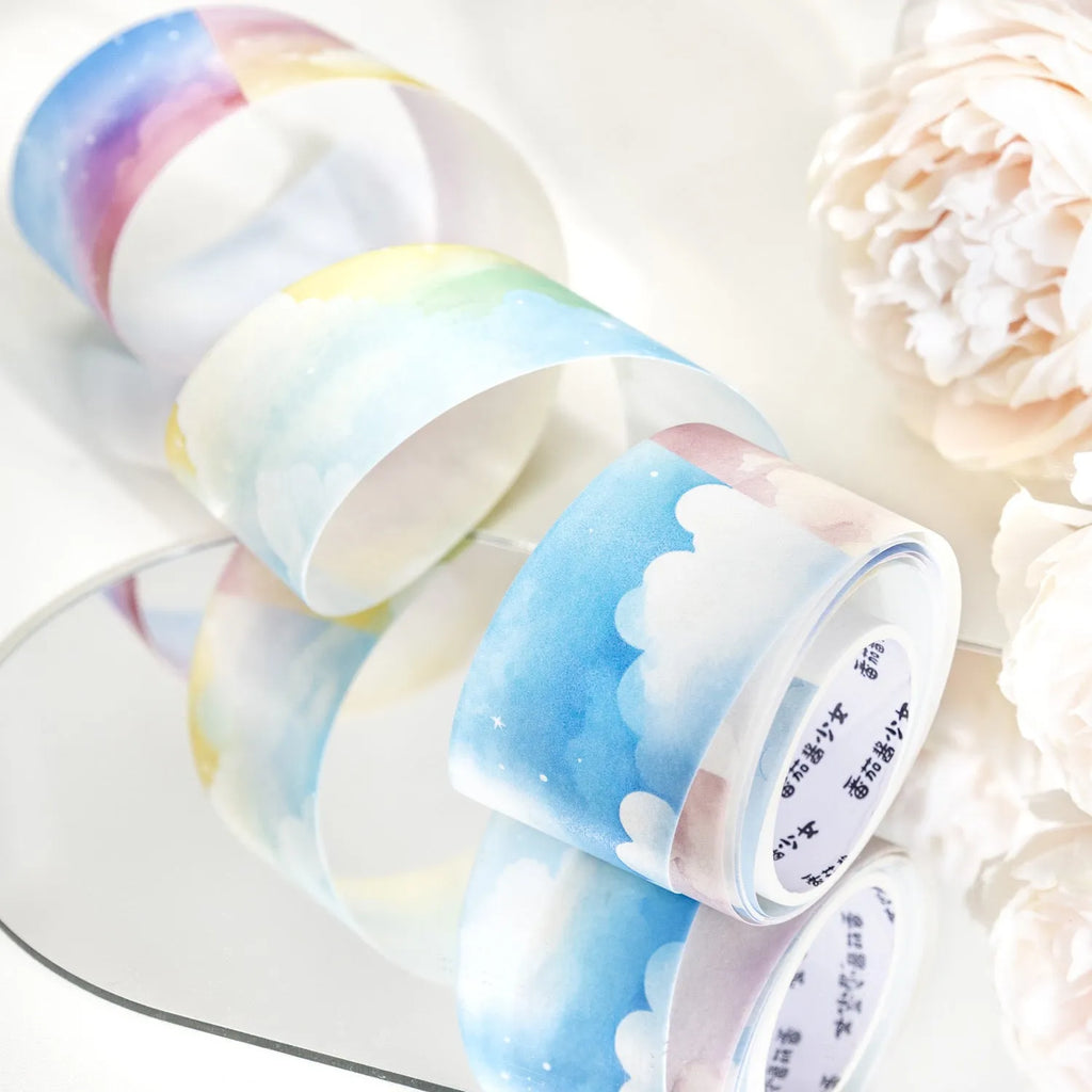 Roll of Japanese washi tape with sky theme designs including clouds, sun, moon, and nebula on a 30mm wide format.