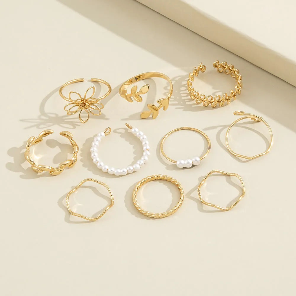 Gold coloured openwork flower design ring for women on a white background.