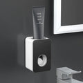 Wall-mounted automatic toothpaste dispenser with punch-free fixing, shown in black, grey, pink, green and white options