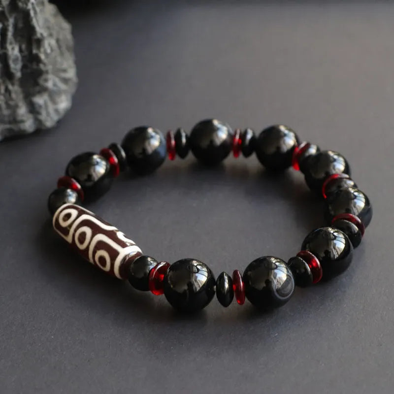 Hand-woven black agate Dzi bracelet with geometric 11mm beads on wrist