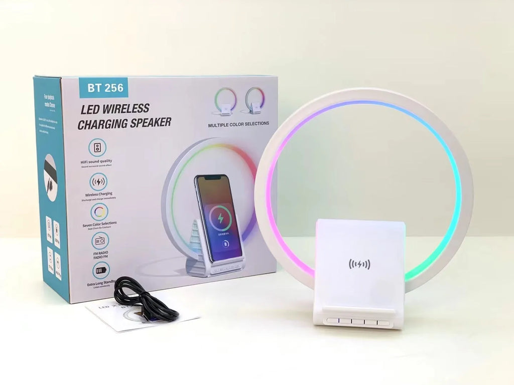 White portable Bluetooth speaker with integrated wireless charging pad and ambient lighting.