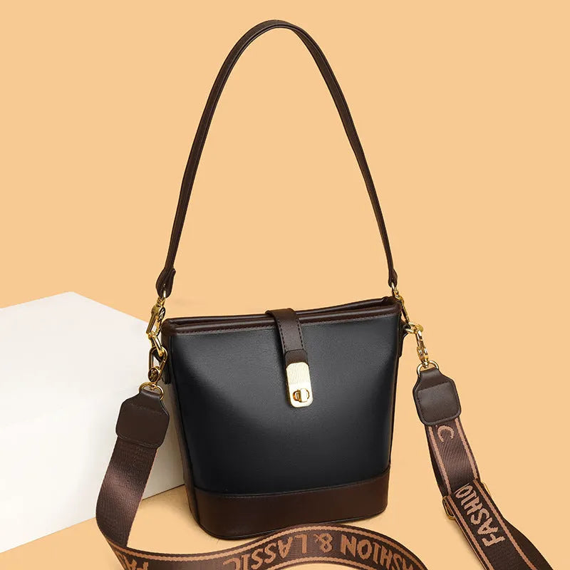 Soft black PU bucket style messenger bag with double shoulder straps, shown open to reveal internal organiser pockets.