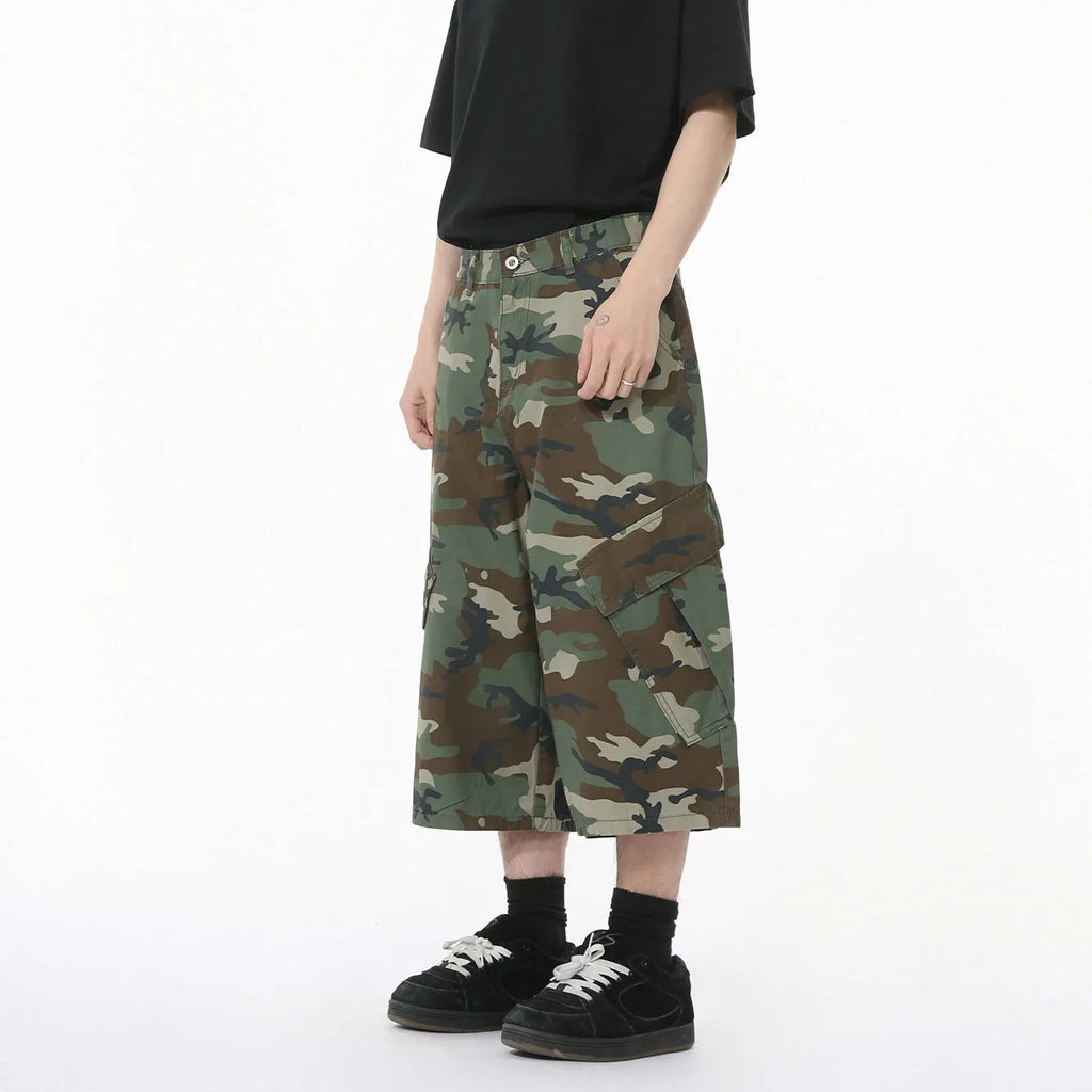 Men's camouflage-coloured cotton jeans with wide loose legs, cropped length, and side pockets on a plain background.