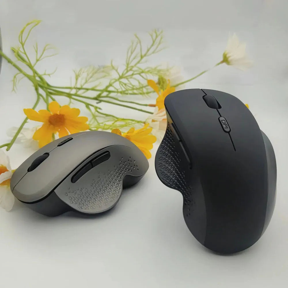 Compact black wireless recharging mouse for laptops with USB cable on a desk.