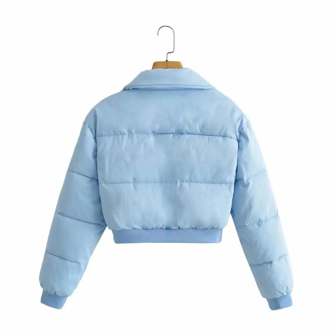 Women's loose-fit blue polyester jacket with long sleeves on a hanger.