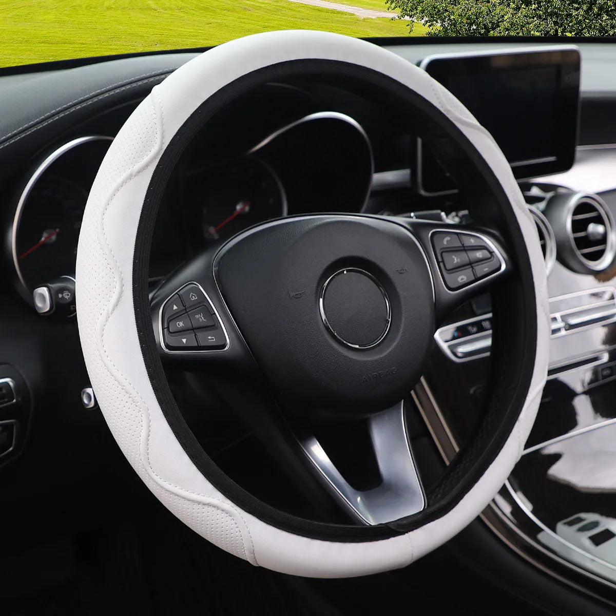 Embossed corrugated elastic steering wheel cover in black, shown fitted on a car steering wheel.