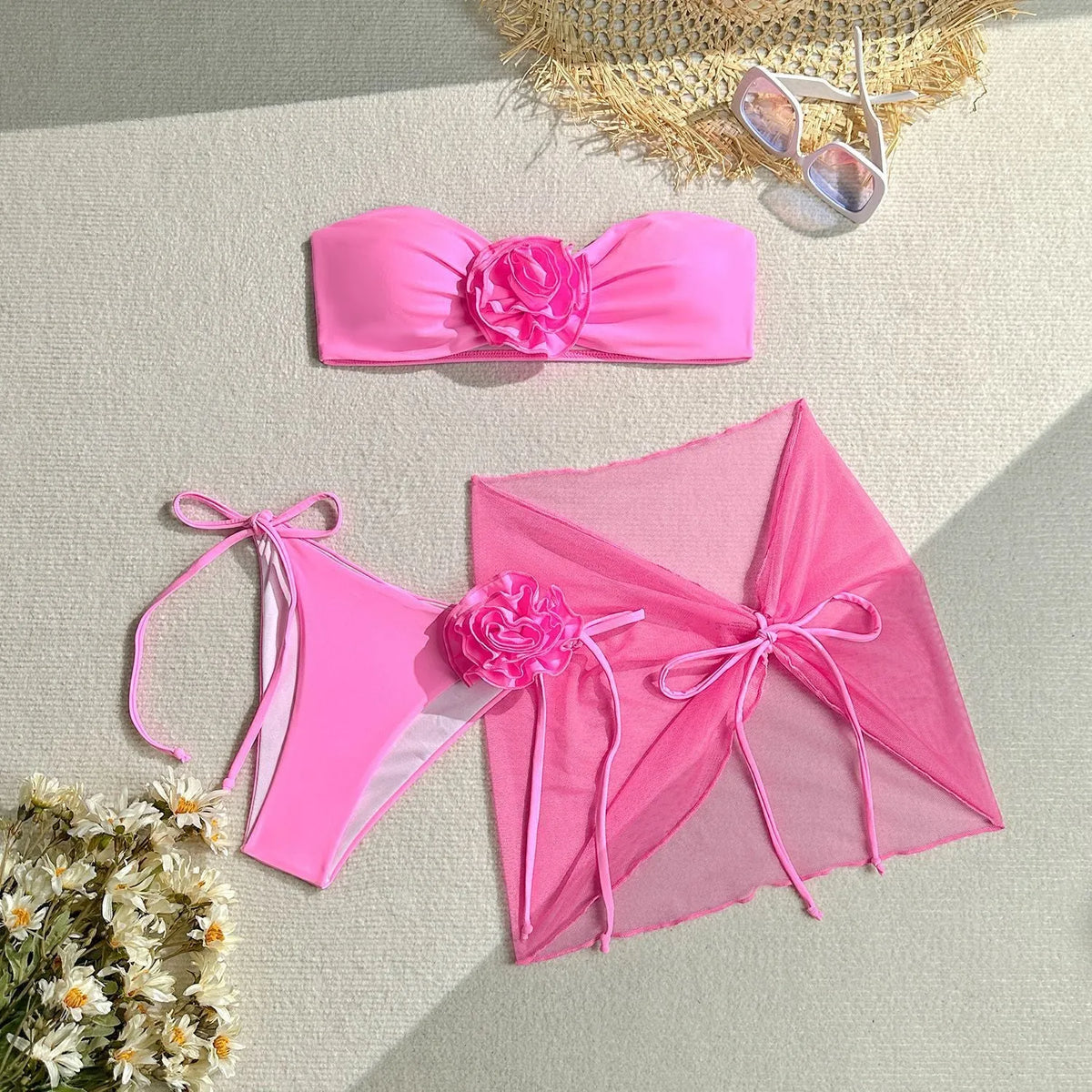 Women's pink swimsuit set with three-dimensional floral tie front tube top, high-waisted pants, and matching skirt.