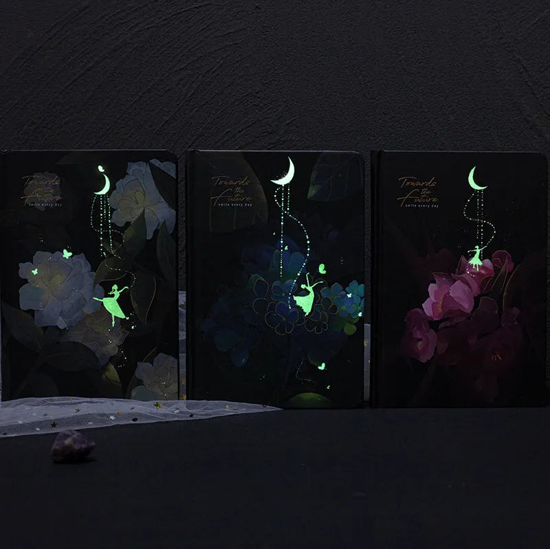 A5 diary notebook with luminous holographic cover open to show pages with colour illustrations.