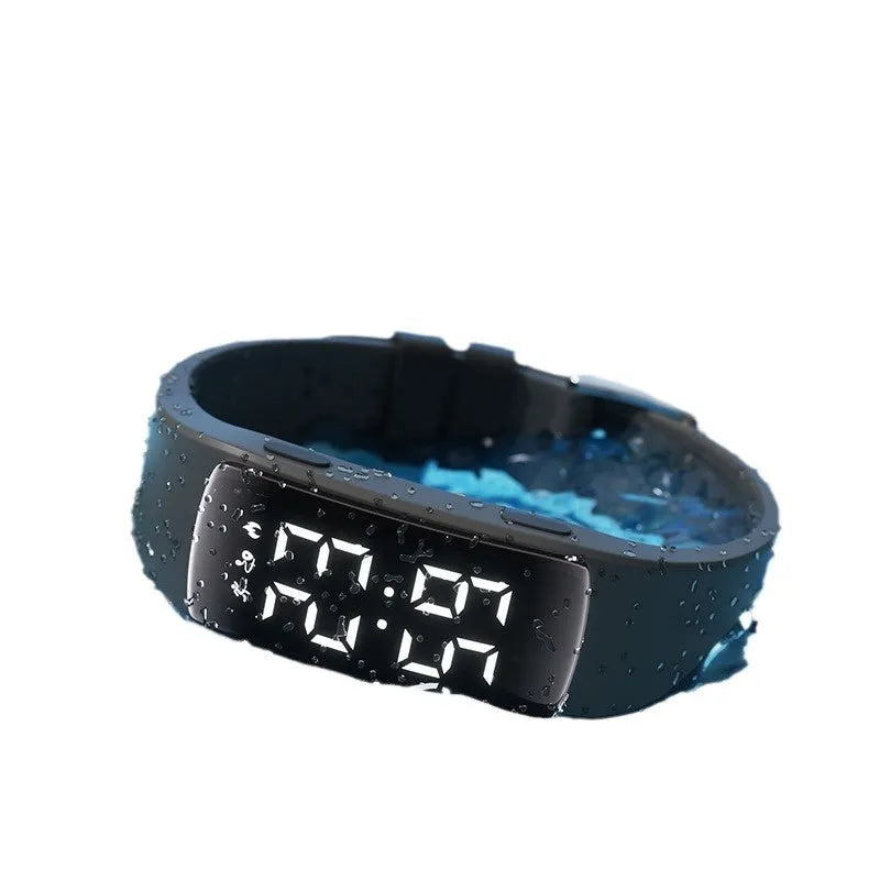 Vibration alarm clock smartwatch with a coloured silicone strap on a wrist, showing its LED display.