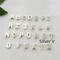 Gold heart shaped alloy pendant with initial letter on white background