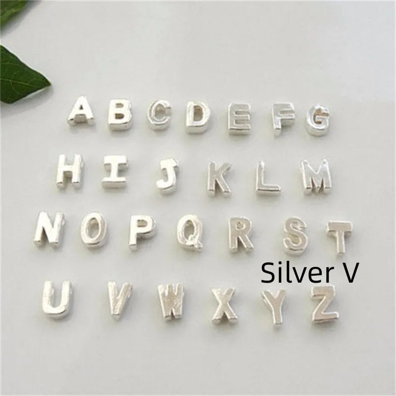 Gold heart shaped alloy pendant with initial letter on white background