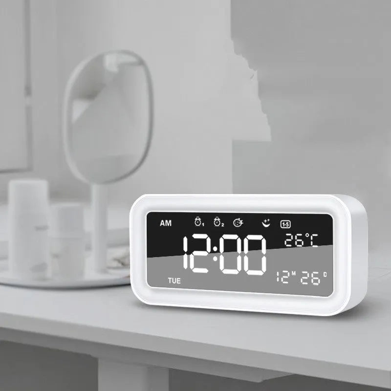 Blue rectangular LED atmosphere light and digital alarm clock on a table.
