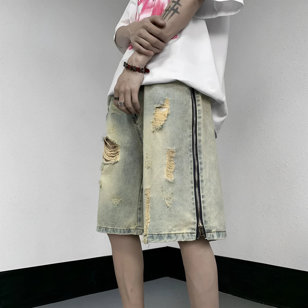Blue men's loose fit denim shorts with distressed rip details and a yellow mud wash finish.