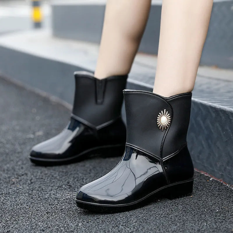 Women's middle tube PVC rain boots in beige, black, and purple with a non-slip sole.