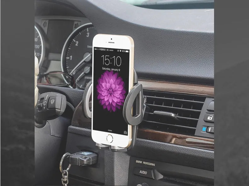 Black plastic car mobile phone holder mounted on air conditioning vent holding smartphone