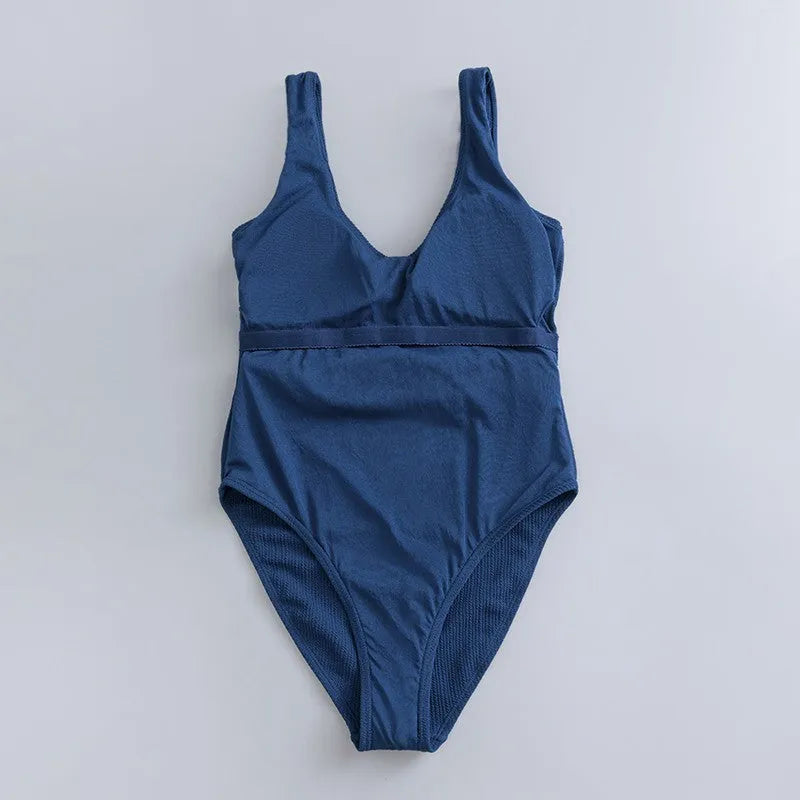 Navy blue women's one-piece triangle swimsuit on a hanger.