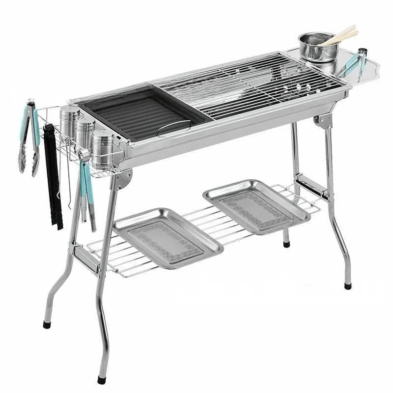 Stainless steel portable folding barbecue grill oven set up outdoors.