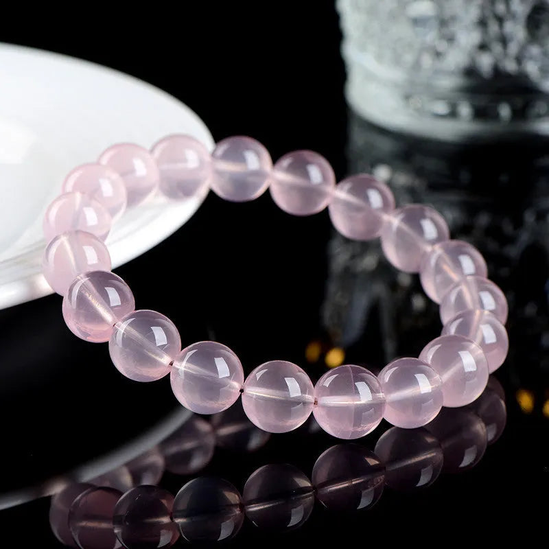 Women's crystal bracelet with round polished beads in pink, showing size options from 6mm to 22mm diameter