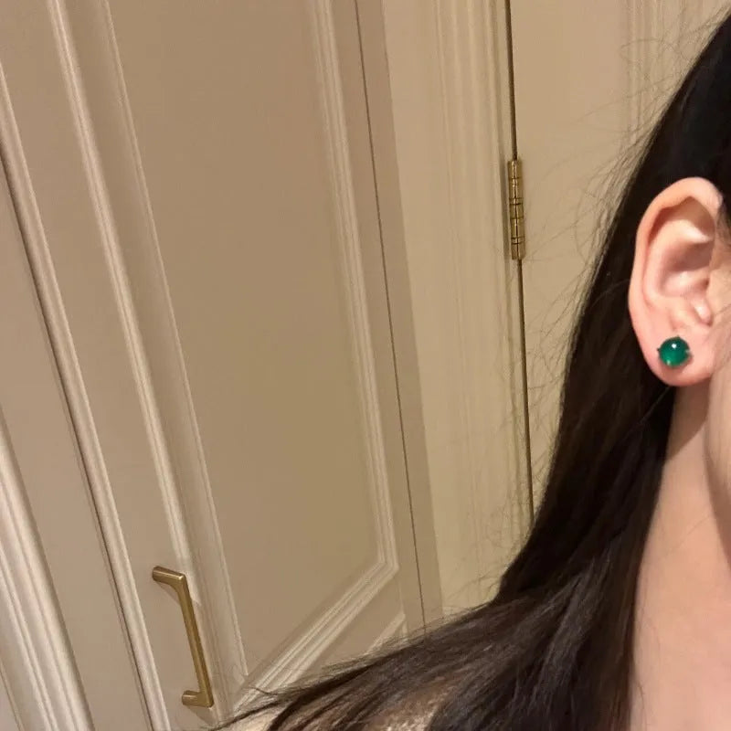 A pair of Chinese-style retro stud earrings with a round egg-shaped chalcedony stone in a four-claw copper setting.