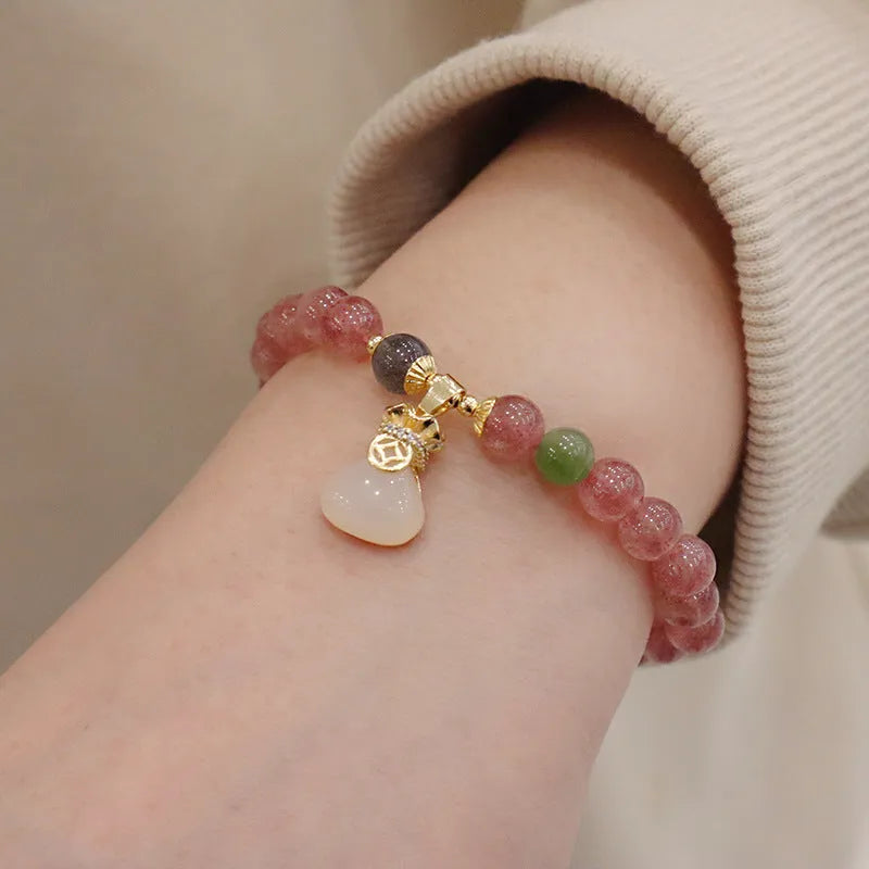 Natural strawberry quartz women's bracelet with purse charm detailing and peace buckle clasp