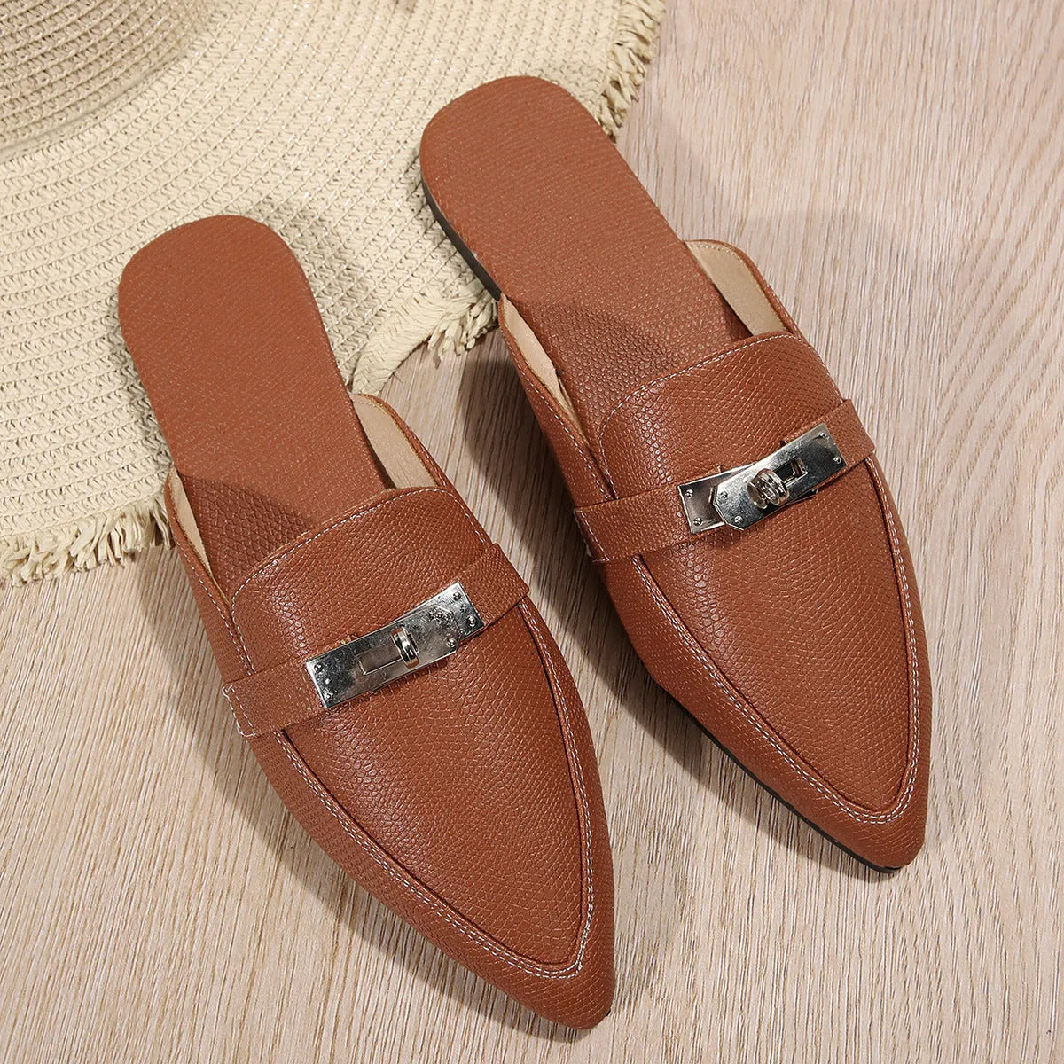 Light brown women's pointed-toe slippers with low heel design on white background