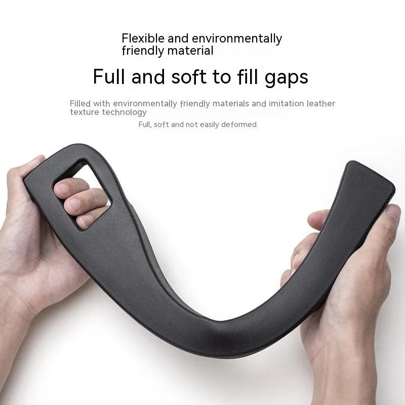 Black plastic car seat gap storage organiser box with a handle, shown inserted between vehicle seats.