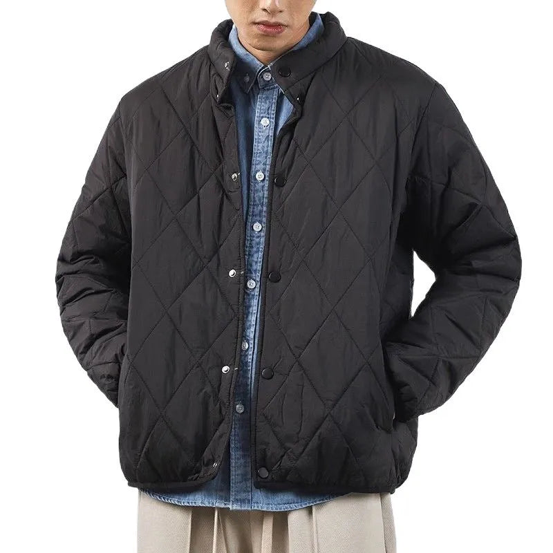Man wearing a black diamond lattice quilted long-line winter jacket with a loose fit.