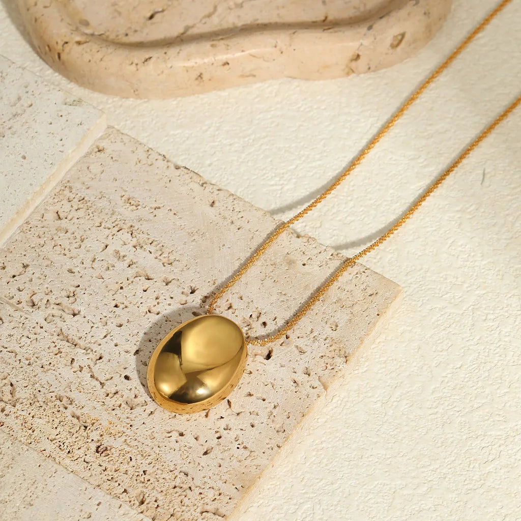 Gold-plated geometric pendant necklace with adjustable chain on model