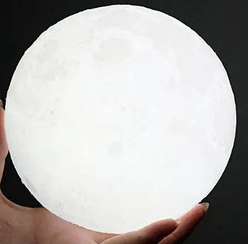 3D printed white moon lamp on a wooden stand with touch control ring at base