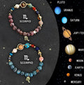 Two natural stone beaded bracelets with zodiac sign charms on a wooden surface.