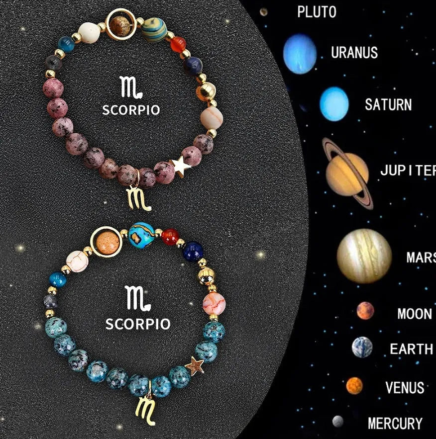 Two natural stone beaded bracelets with zodiac sign charms on a wooden surface.
