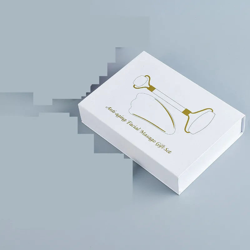 Natural white jade facial roller and gua sha scraping board set on a white background.